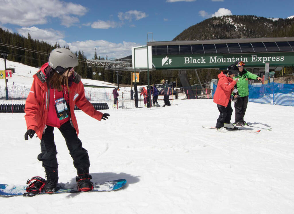 Young snowboarder coming to stop at base of hill