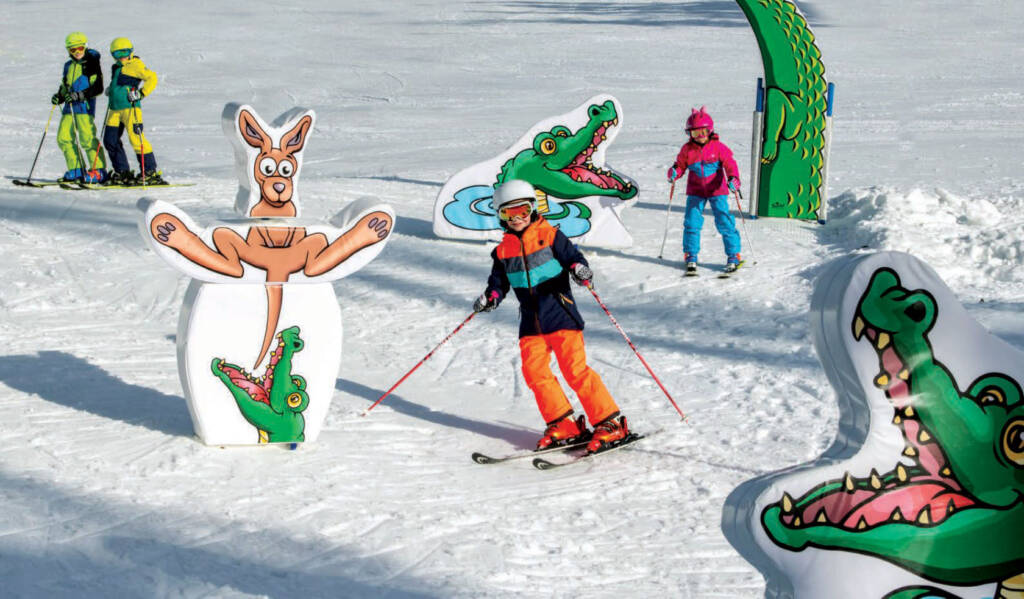 Young skiers skiing around large cartoon cut-outs