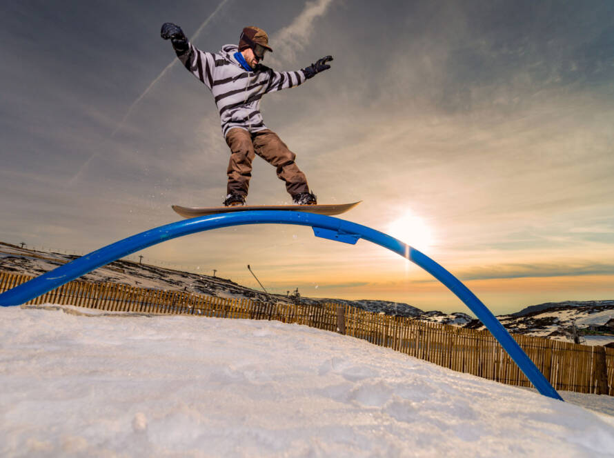 Snowboarder riding rail obstacle