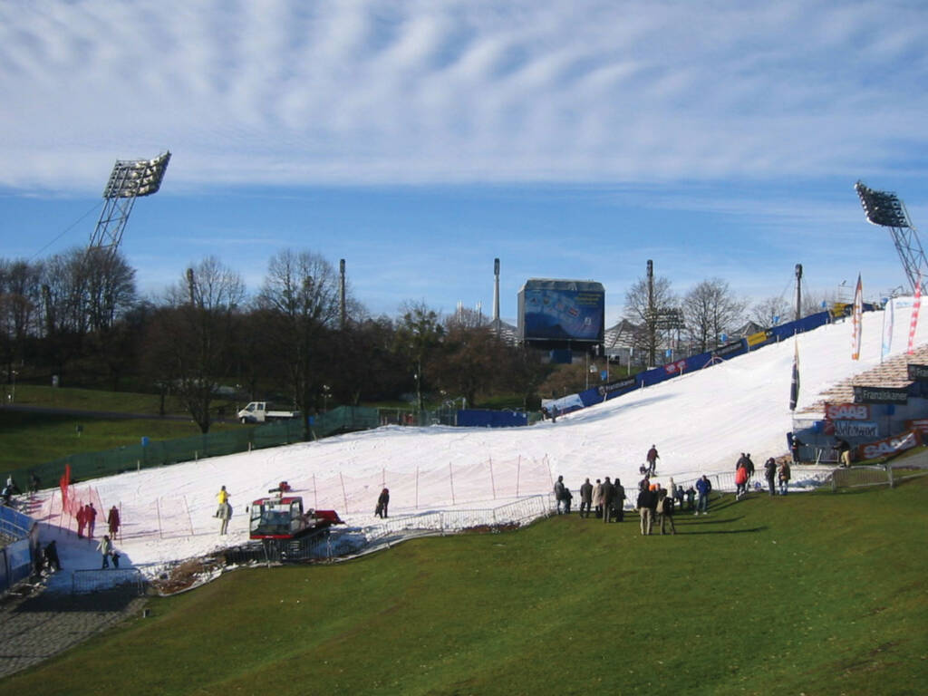 Spectators watching snowboarder descending artificial snow slope