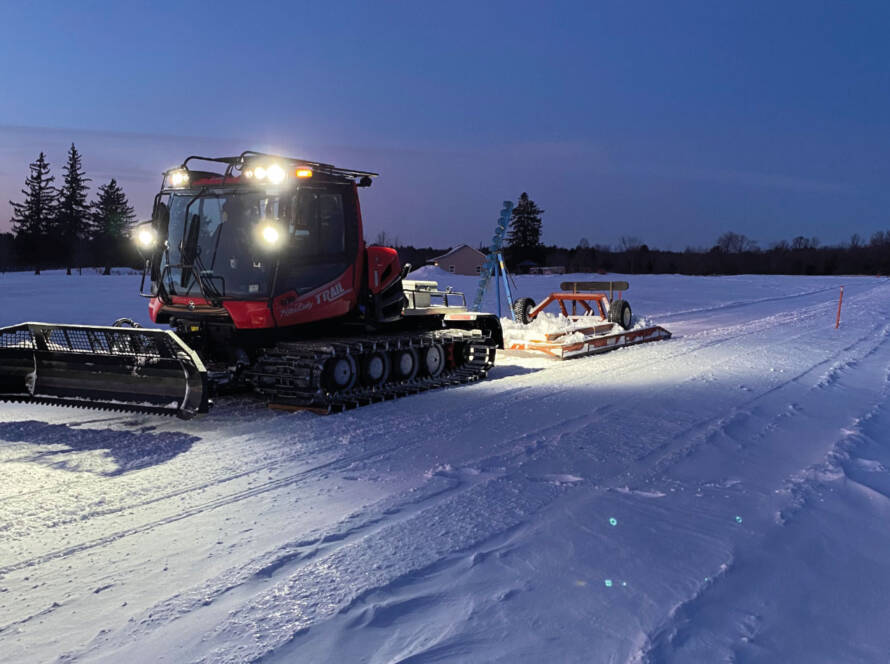 PistenBully snow groomer with a Mogul Master drag, a brush bar and packer