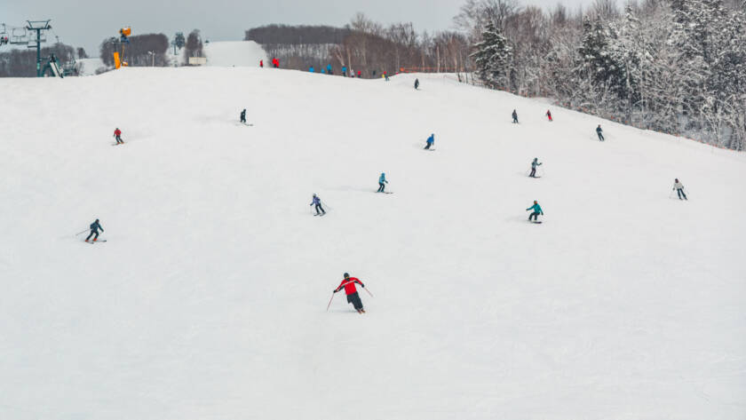 skiers and snowboarders coming down mountain