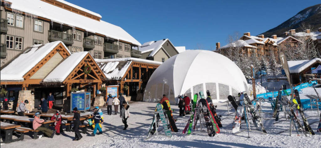 Domed, enclosed tent in front of ski chalet