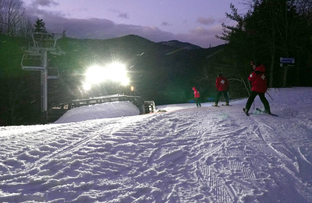 Snow groomer at night