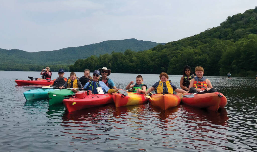 Large group in seven kayaks on lake