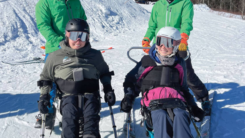 Four skiers in snow gear and specialized ski equipment