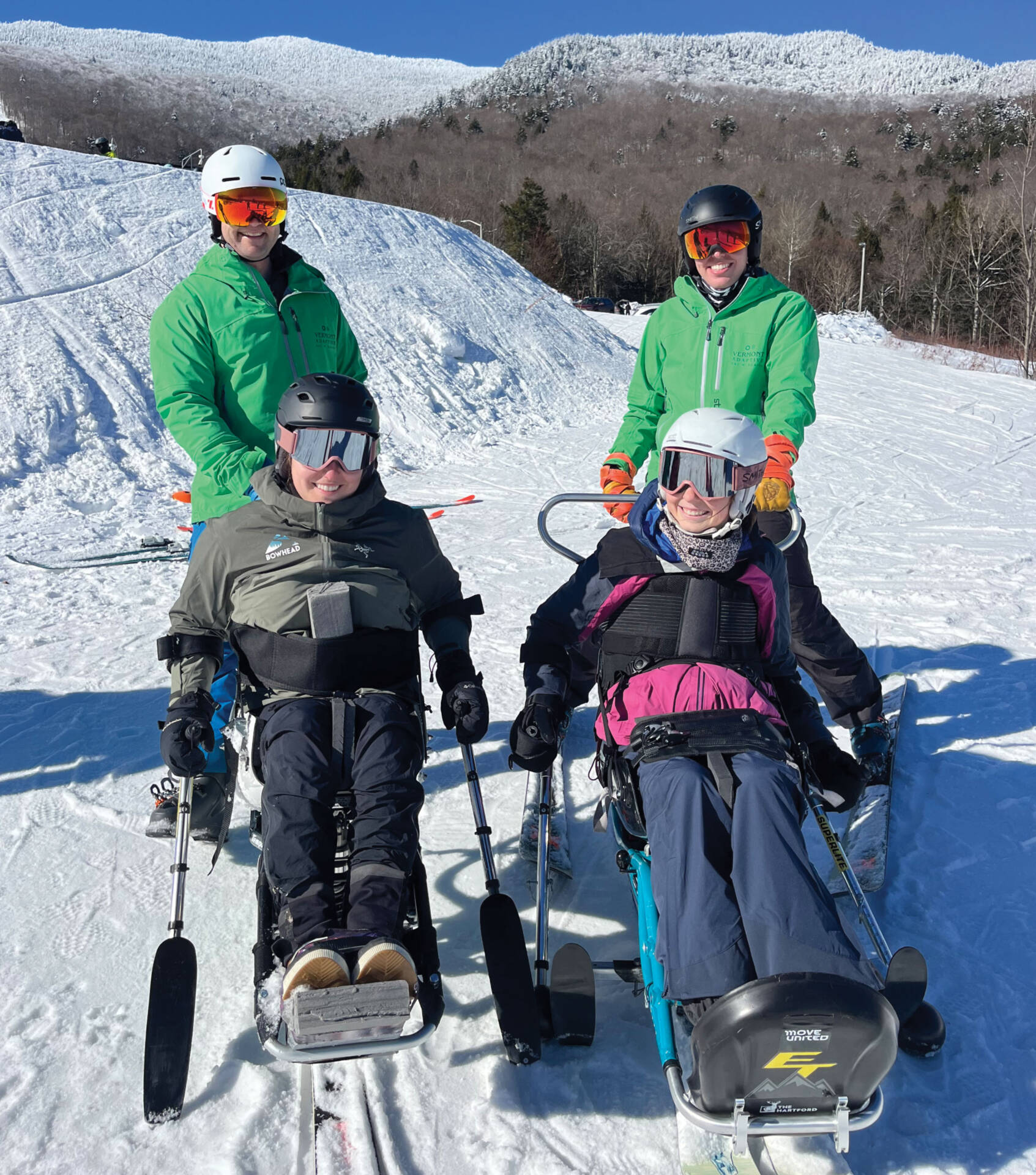 Four skiers in snow gear and specialized ski equipment