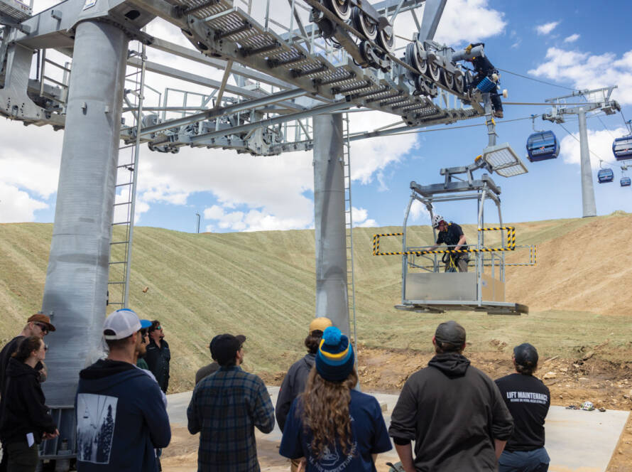 Students watching lift maintenance instructor on ski lift