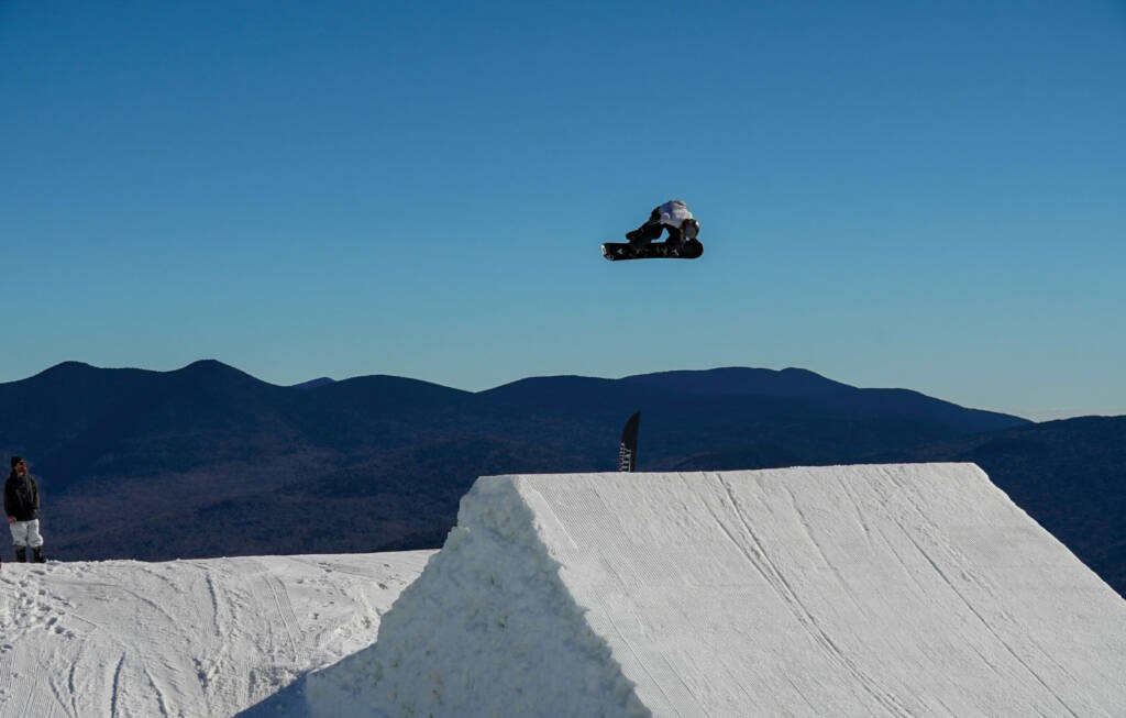 Snowboarding jumping high off ramp