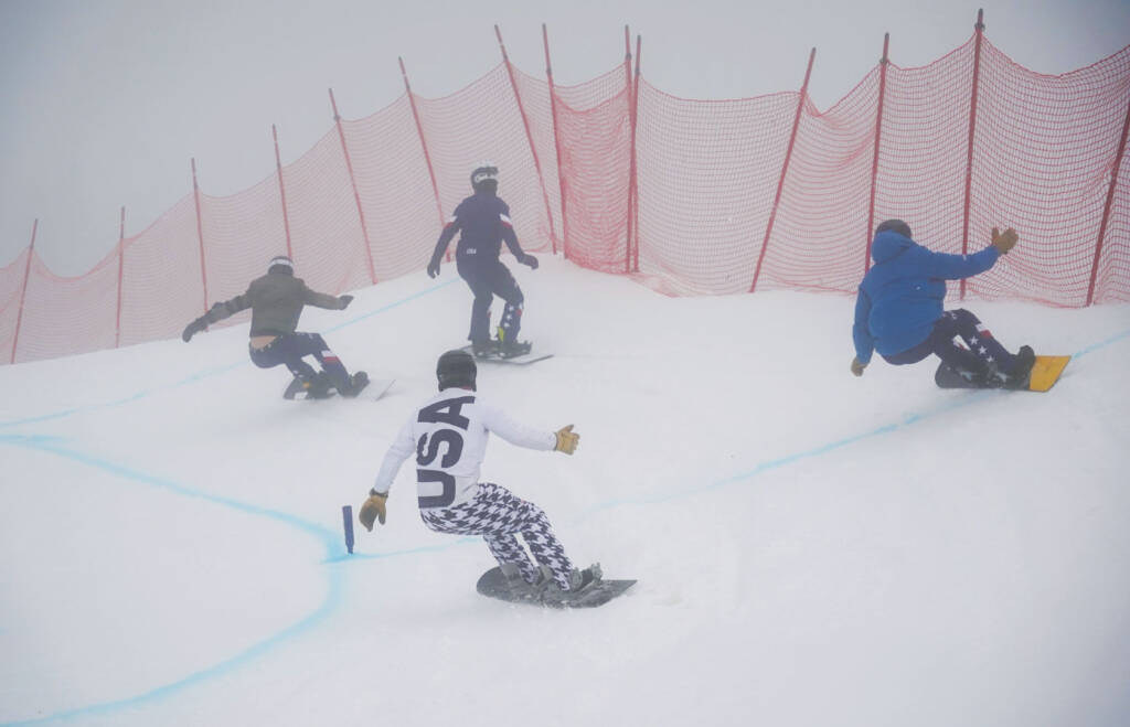 Snowboarders racing on course