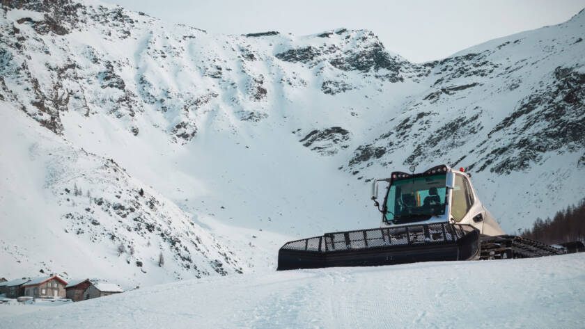 Snow groomer on snow-covered mountain