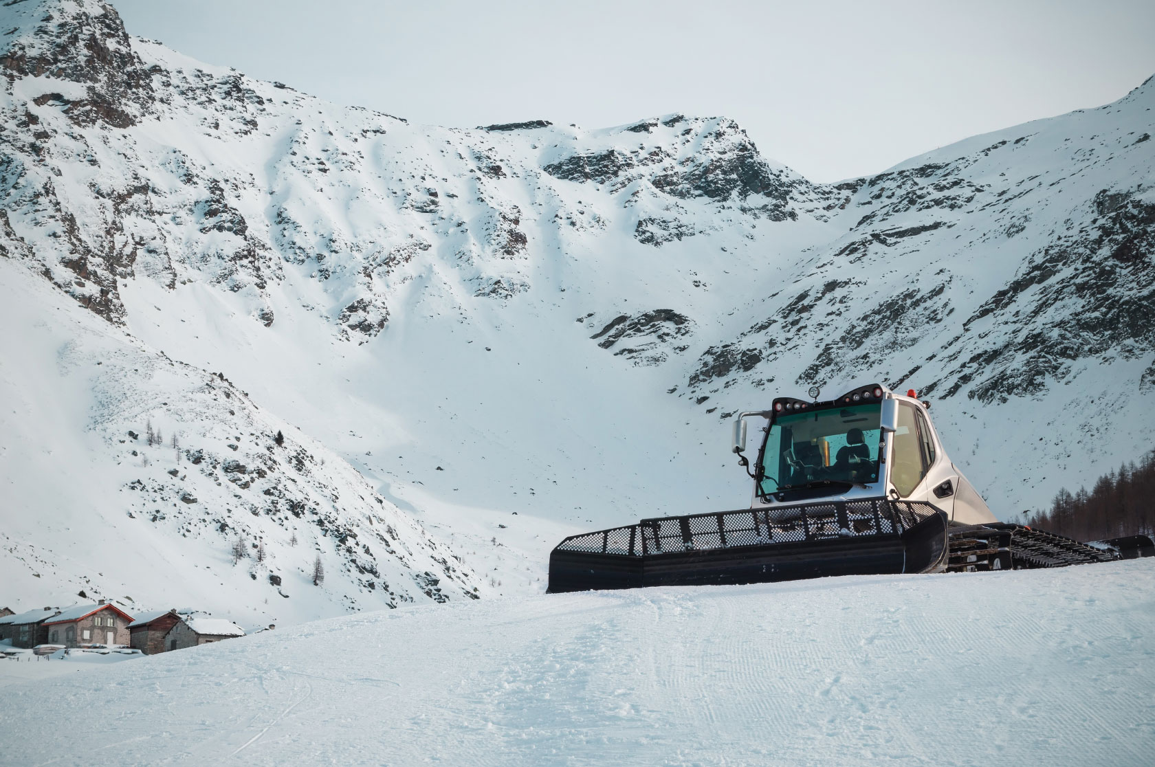 Snow groomer on snow-covered mountain